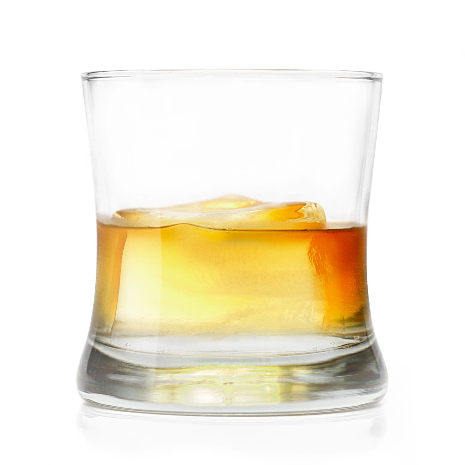 A rocks glass of whiskey against a plain white background, a single large ice cube half submerged