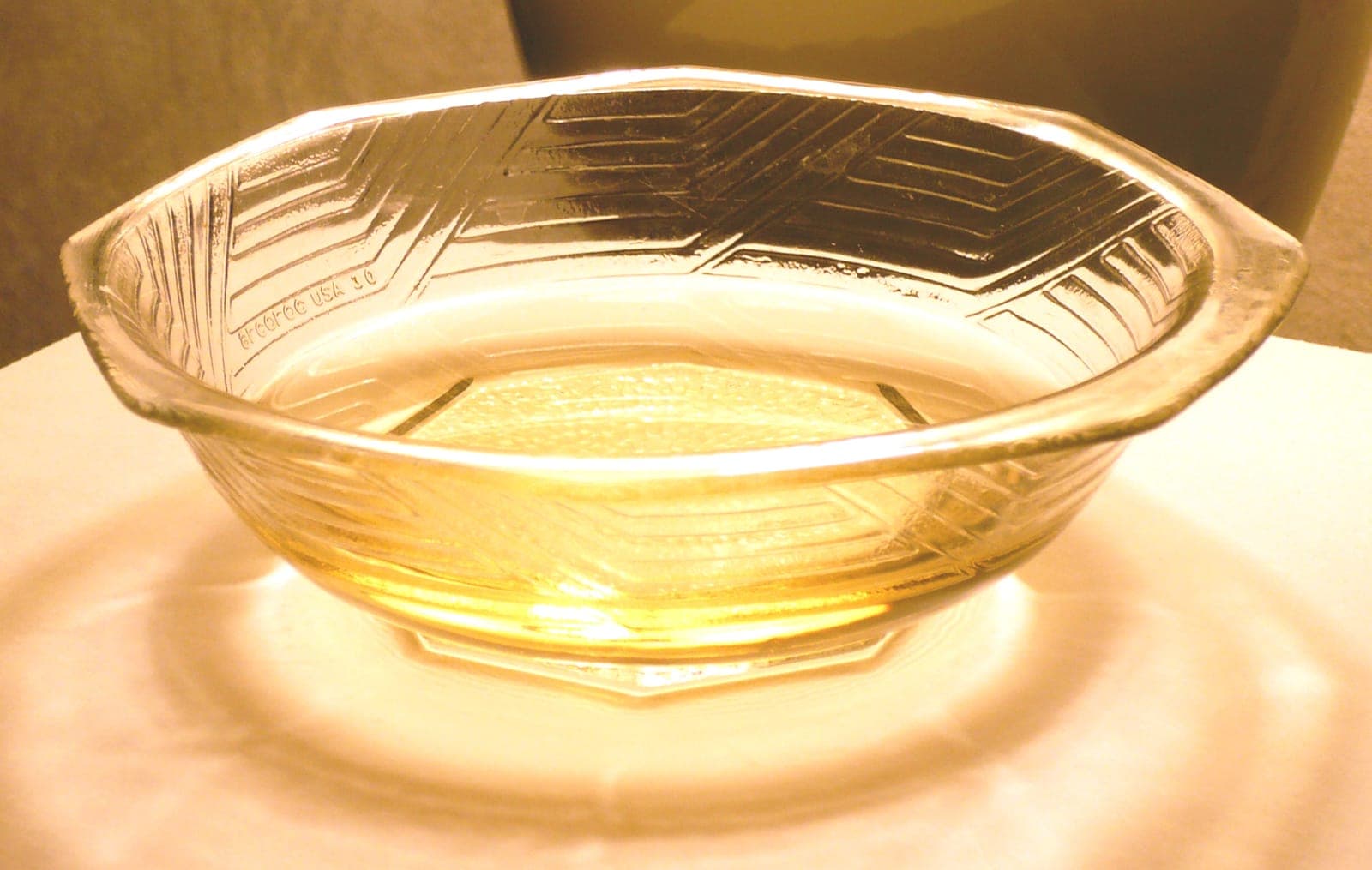 A glass dish holding a small pool of pale gold mirin