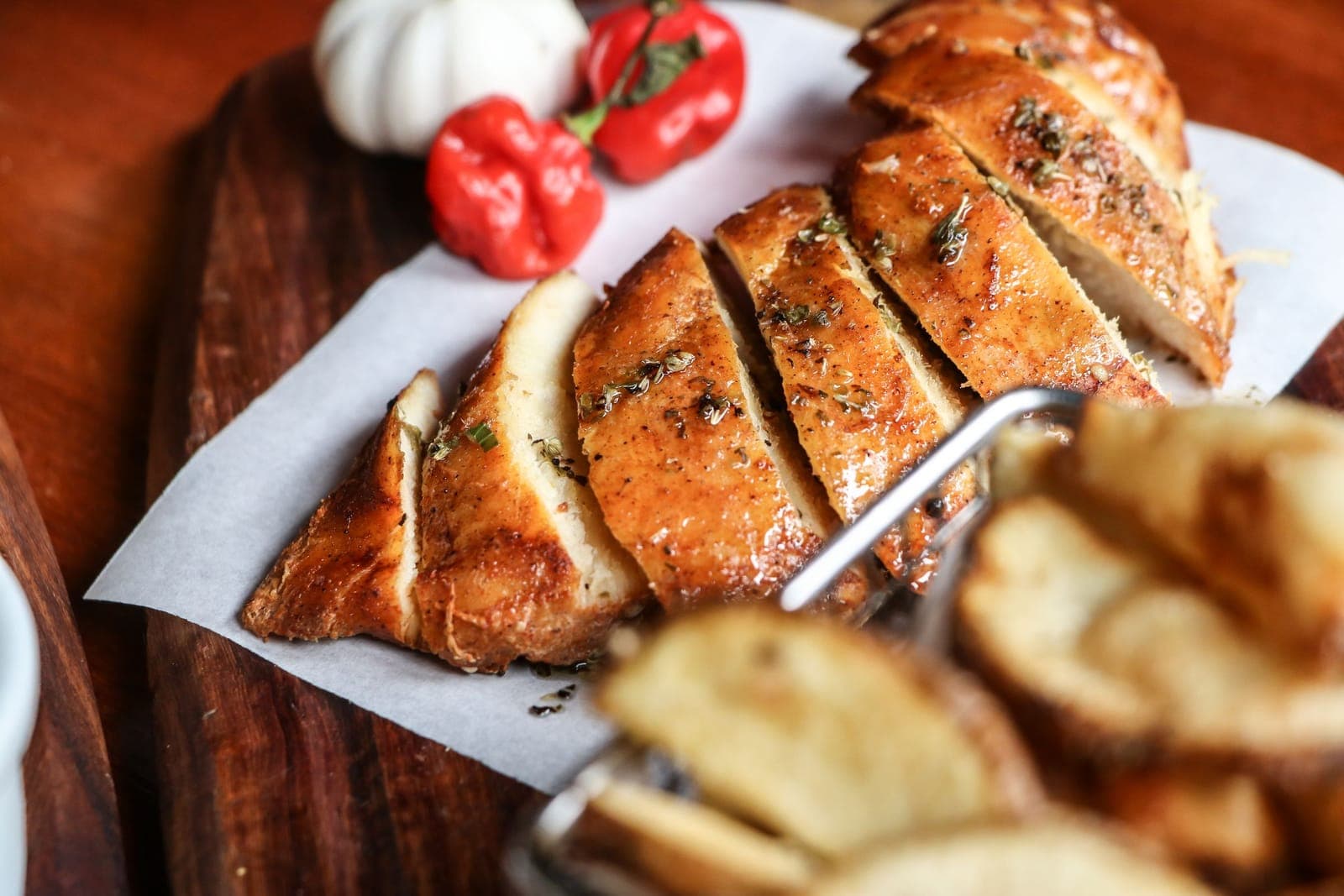 Sliced roast chicken breast on parchment, the interior fully white